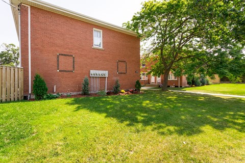 A red brick house with a white window and a white door.