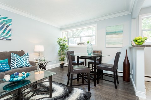 A dining room with a glass table and chairs.
