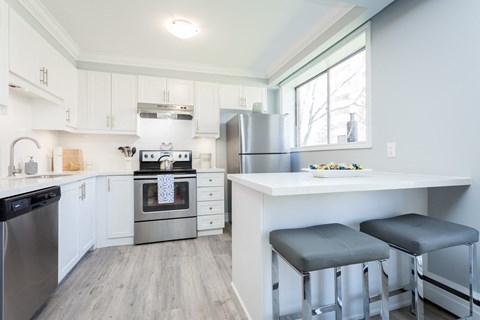 A kitchen with white cabinets and a stainless steel oven.