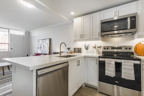 A modern kitchen with a stainless steel oven and white countertops.