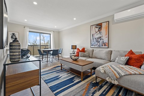A living room with a grey couch, a coffee table, and a painting on the wall.