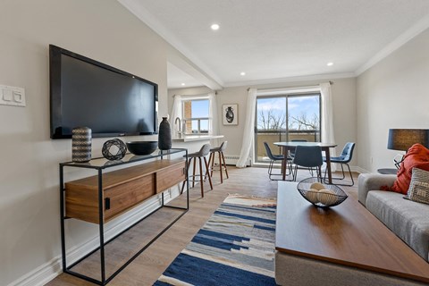 A living room with a television on a stand and a couch.
