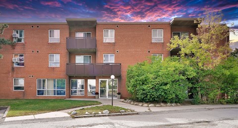 A red brick apartment building with a balcony on the second floor.