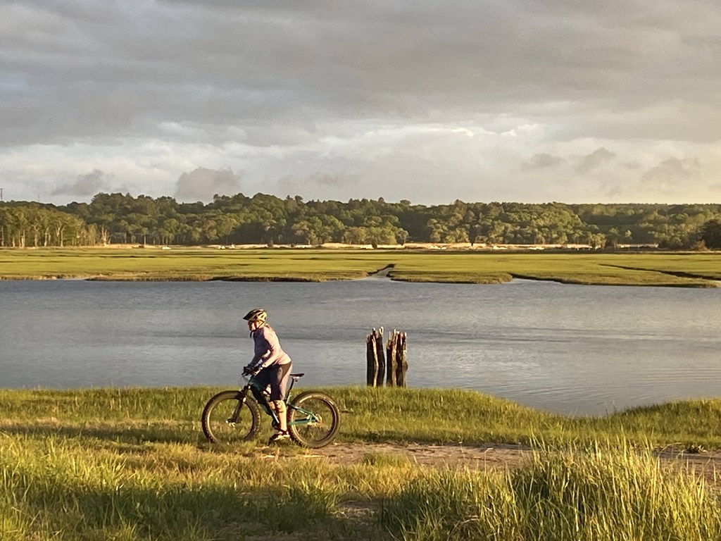 a man riding a bike next to a body of water
