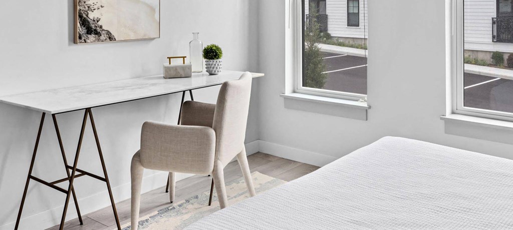 a bedroom with a bed and a desk with a chair