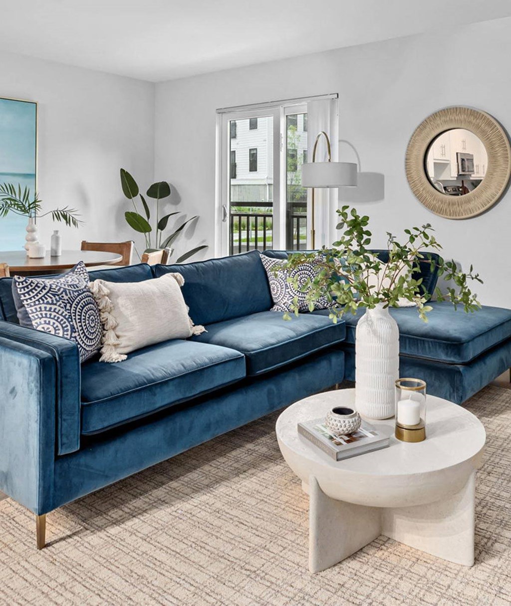 a living room with a blue couch and a white coffee table