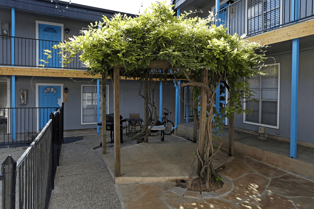 a courtyard with a tree in front of a building