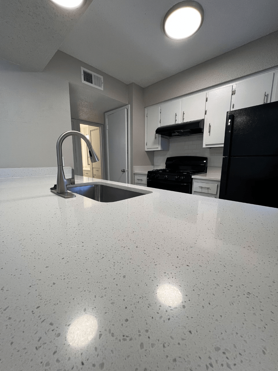 a kitchen with white quartz countertops and white cabinets
