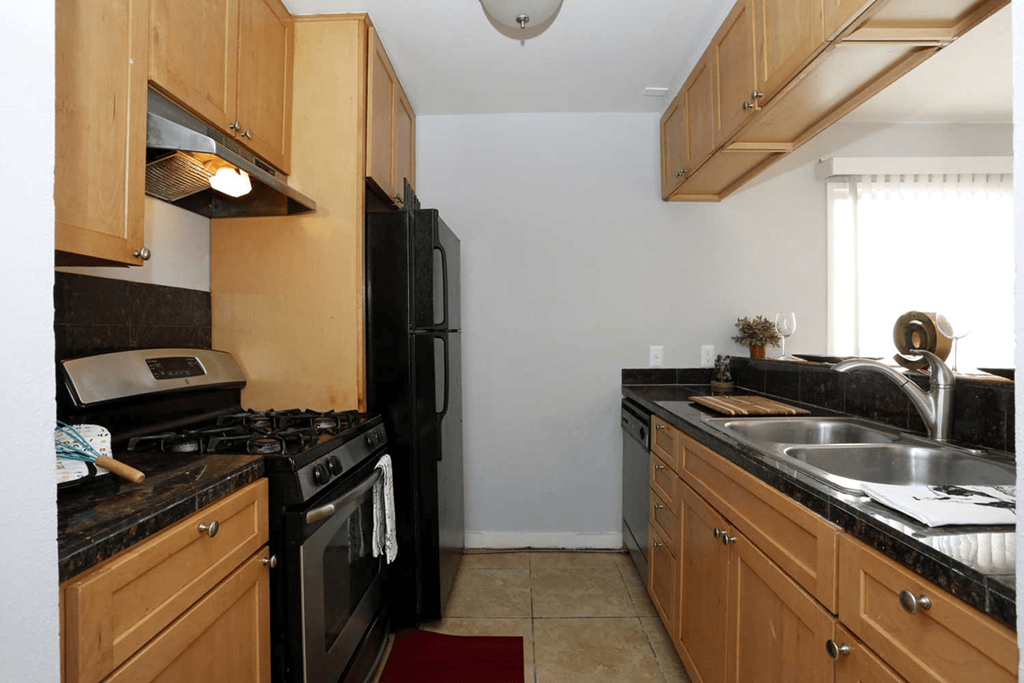 a kitchen with wood cabinets and black appliances