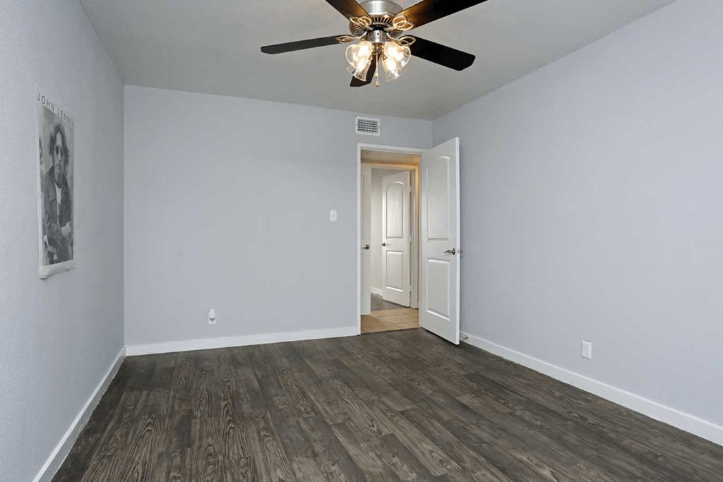 a bedroom with gray walls and a ceiling fan