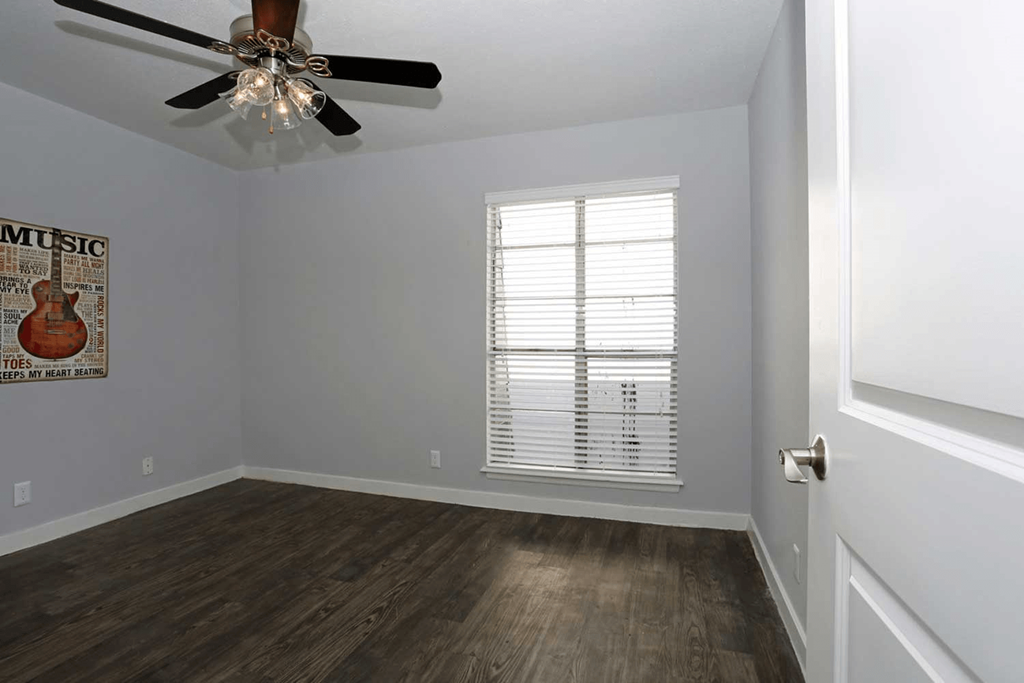 a bedroom with hardwood floors and a ceiling fan