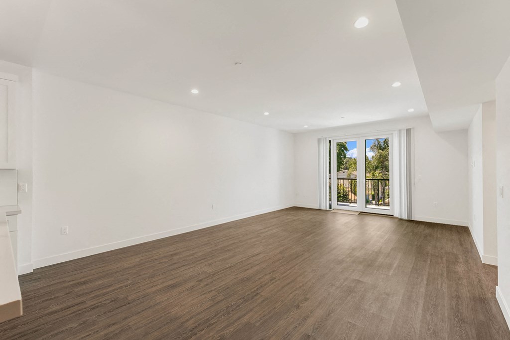 a bedroom with hardwood floors and white walls