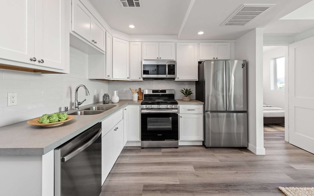 a kitchen with white cabinets and stainless steel appliances