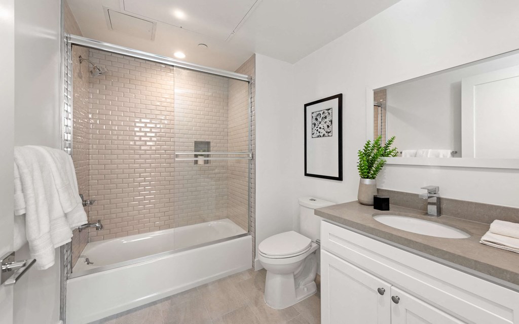 a bathroom with a toilet sink and bathtub in a 555 waverly unit