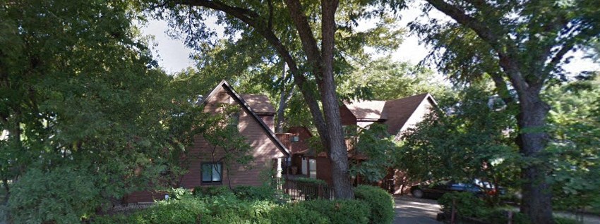 a house surrounded by trees and bushes