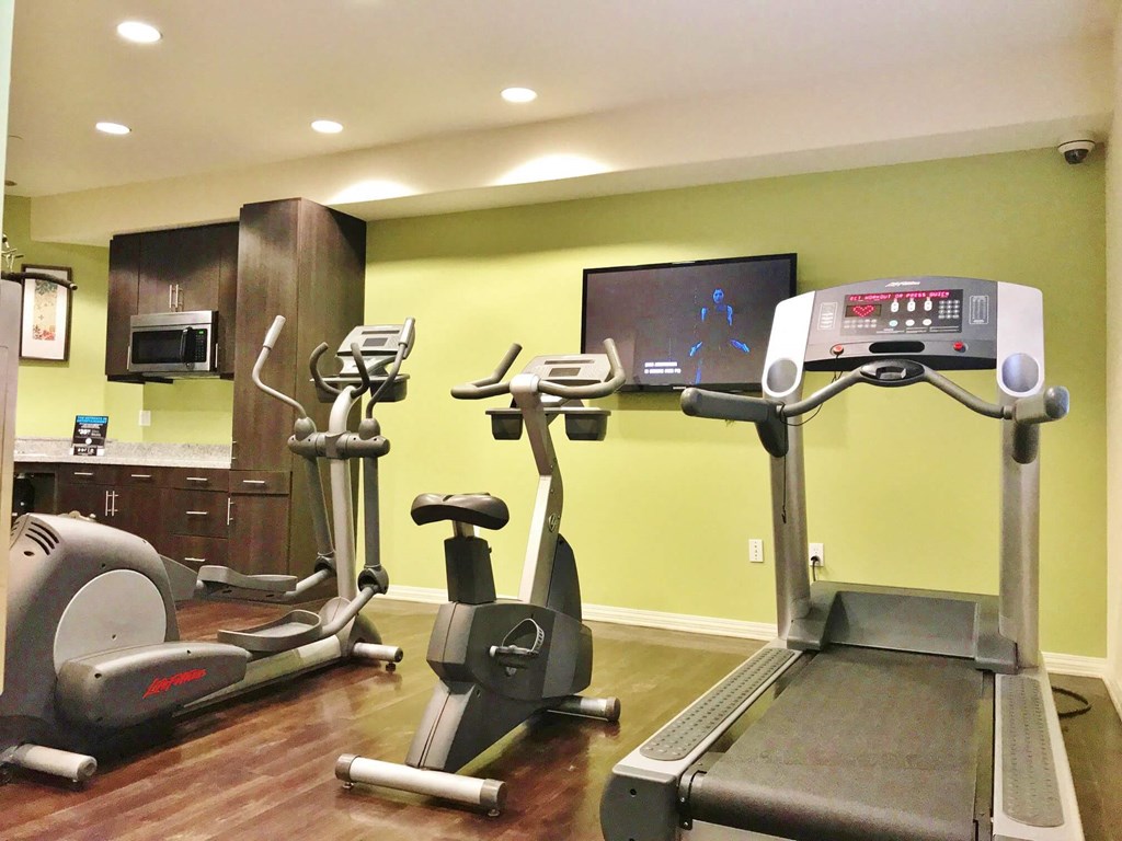 a room with two exercise bikes and a tv