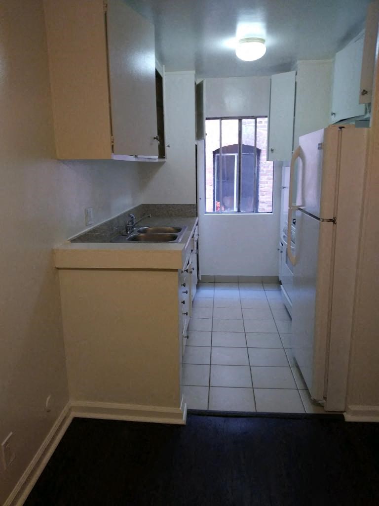 a kitchen with a sink a refrigerator and a window