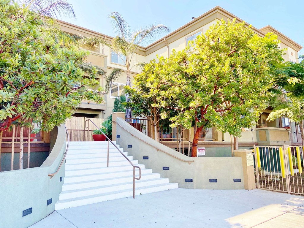 a building with a staircase and trees in front of it