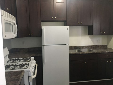 a kitchen with a refrigerator and a sink and cabinets