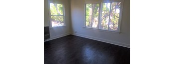 an empty room with a large window and a radiator