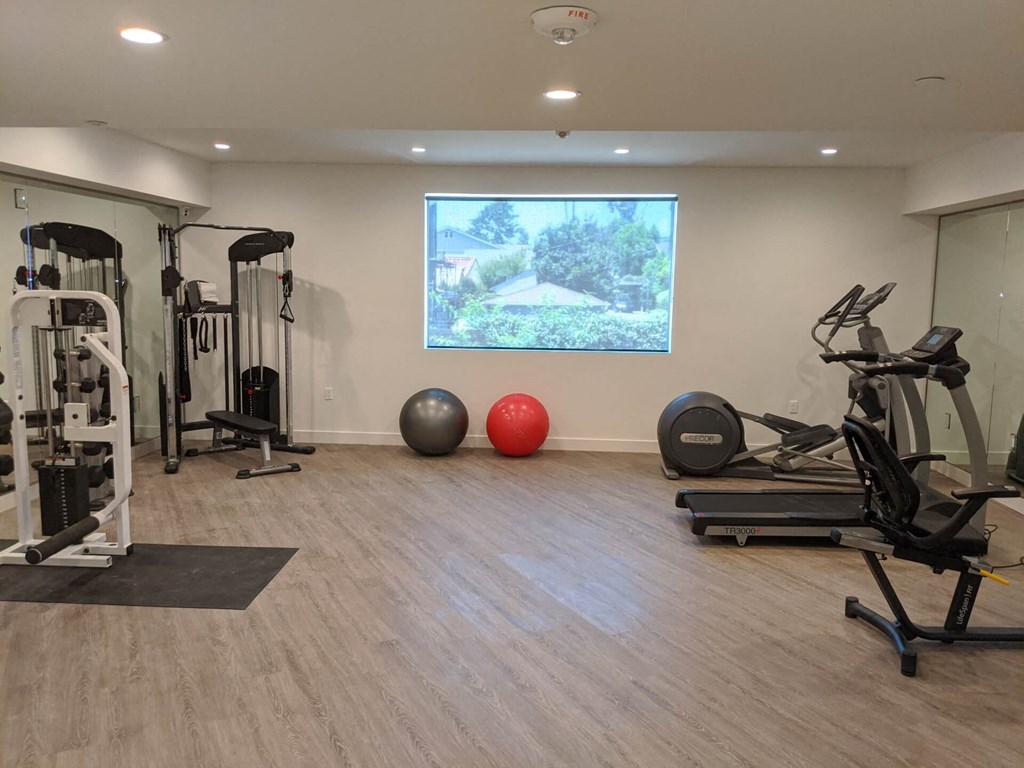a gym with exercise equipment and a large window