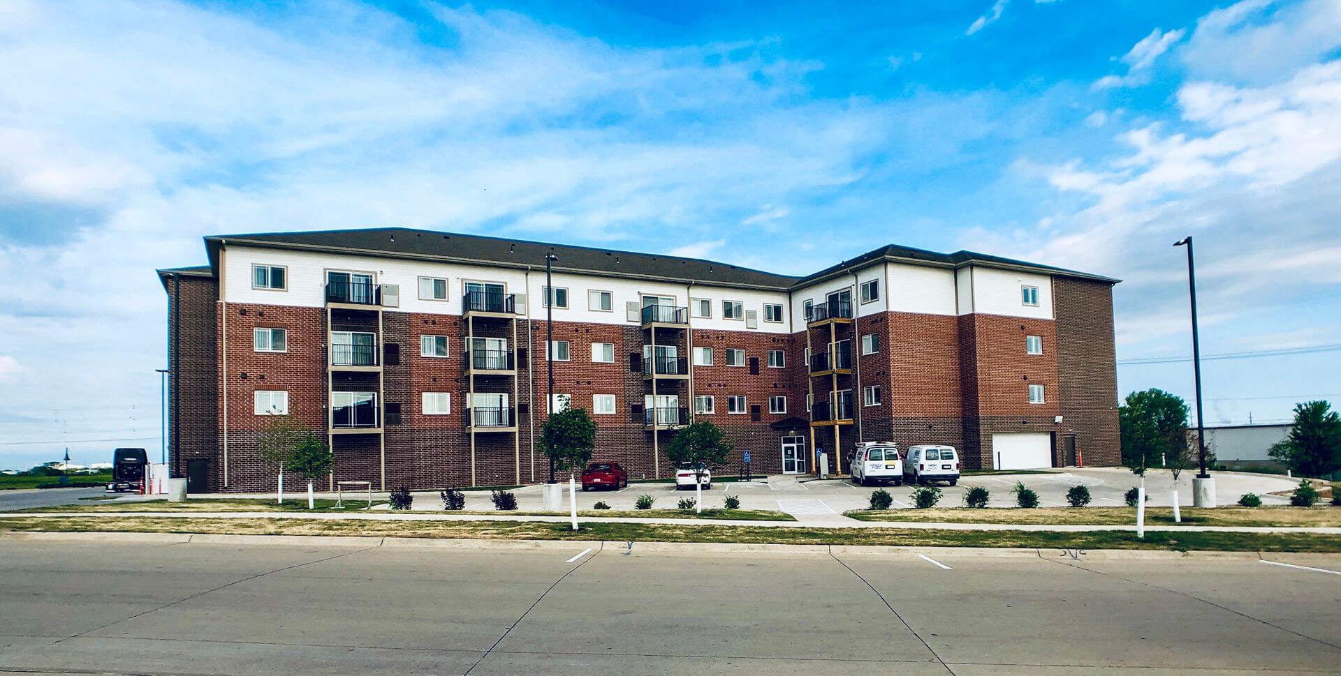 a large apartment building with a parking lot in front of it