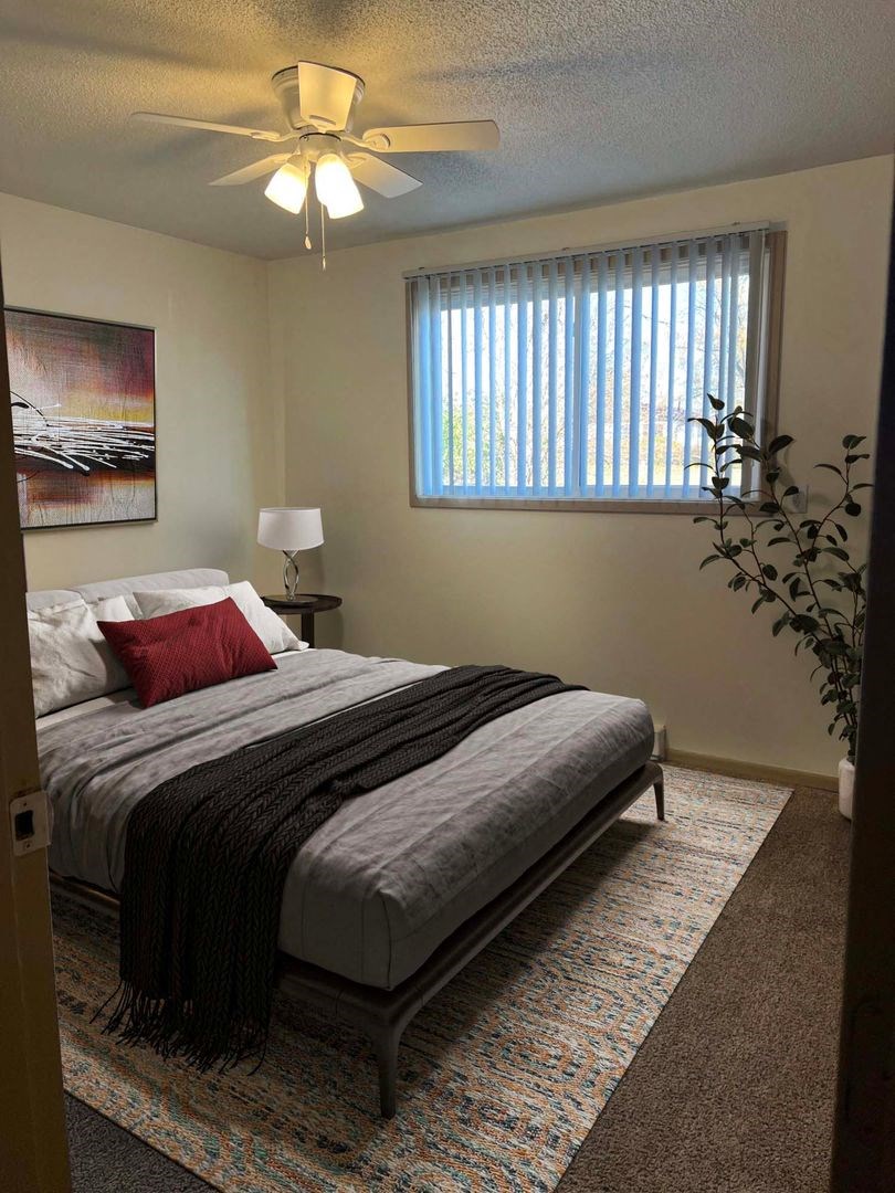 a bedroom with a bed and a ceiling fan