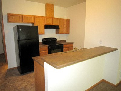 a kitchen with a counter and a black refrigerator