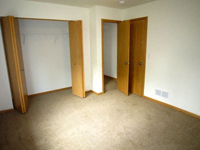 an empty room with three doors and a carpeted floor