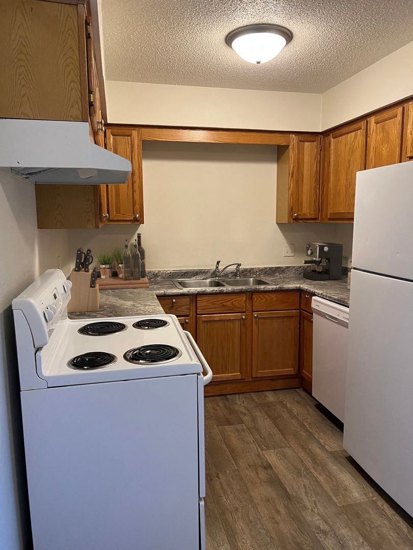 a kitchen with white appliances and wooden cabinets