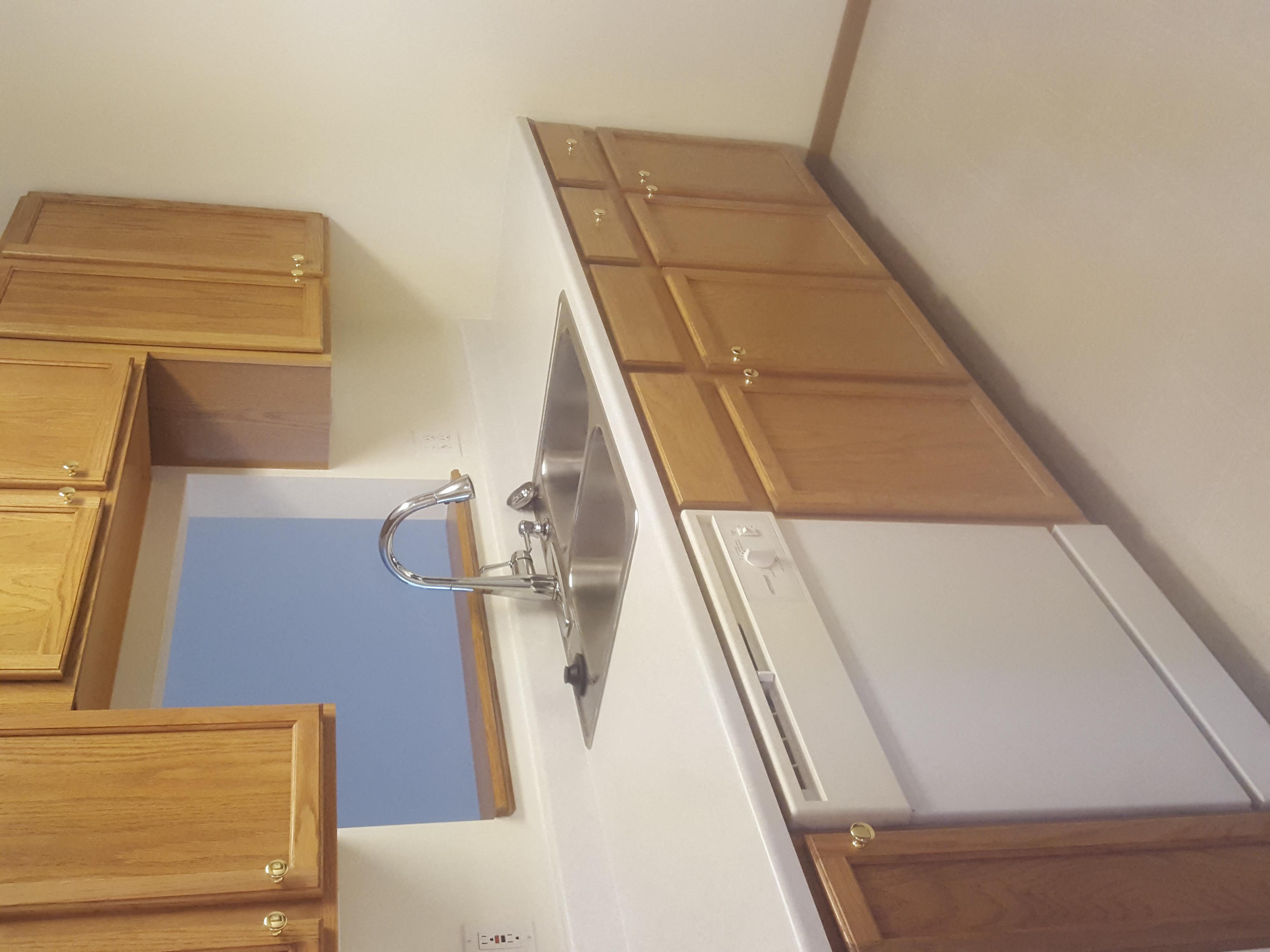 a kitchen with a sink and drawers and a window