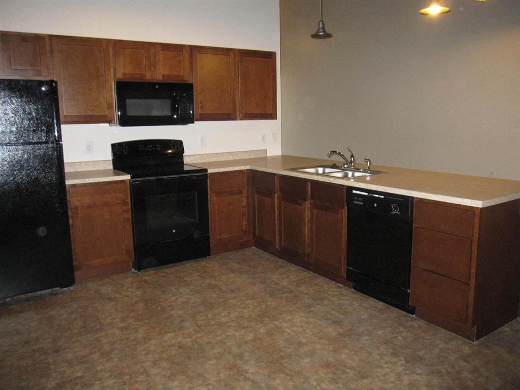 a kitchen with a black stove top oven next to a sink