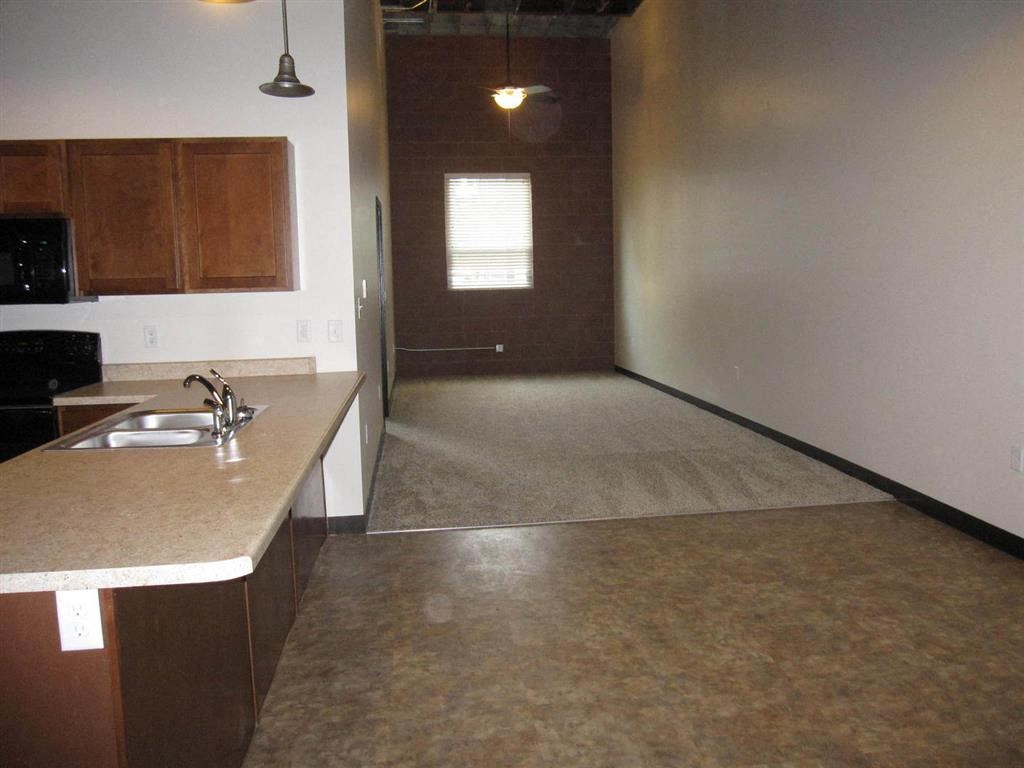 an empty kitchen and living room with a sink