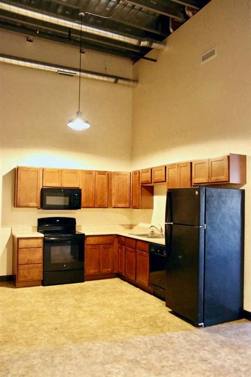 a kitchen with a black refrigerator freezer and a black stove top oven
