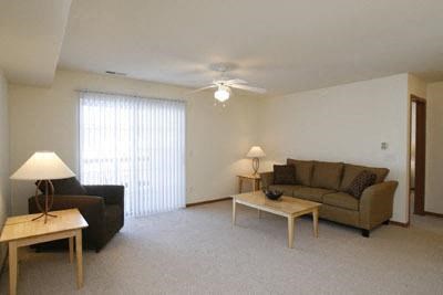 a living room filled with furniture and a ceiling fan