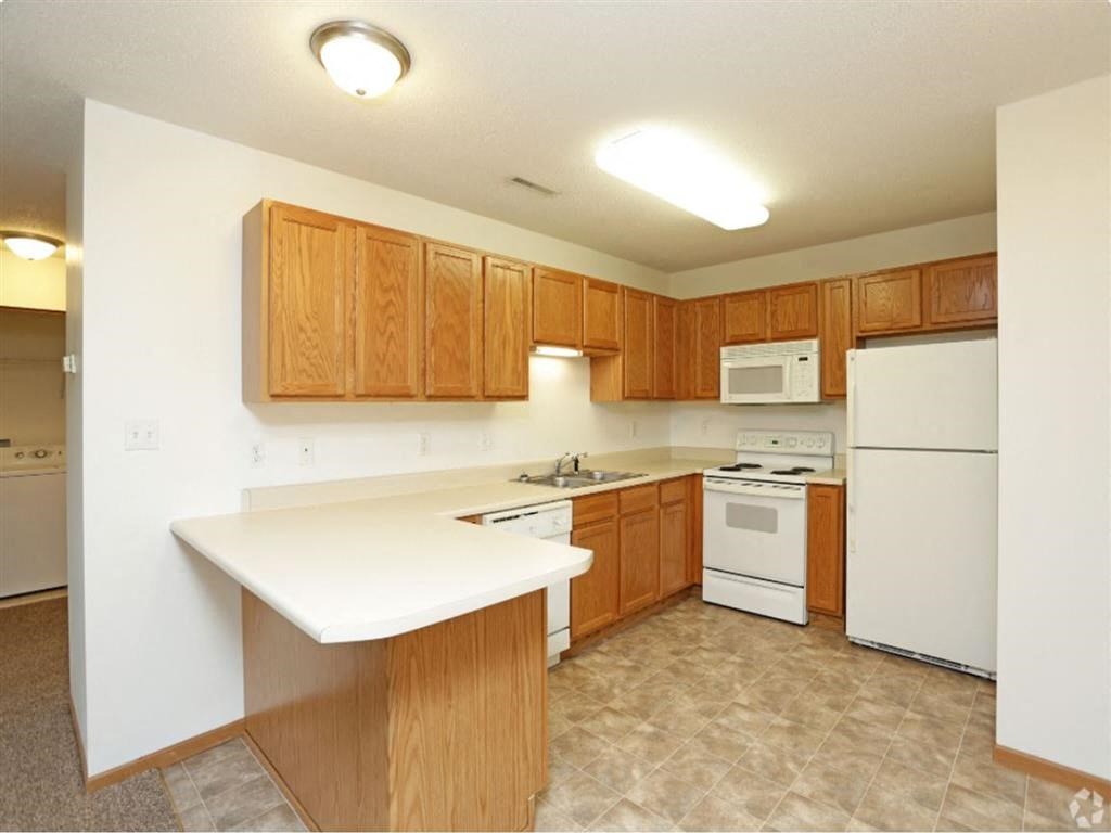 a kitchen with a white stove top oven next to a refrigerator