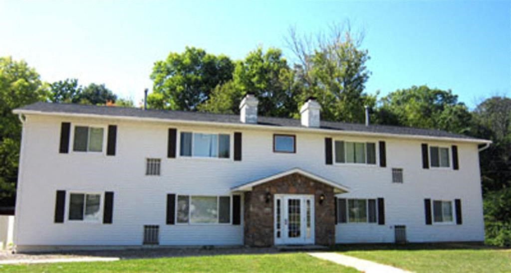 a white house with black shutters and a gray roof
