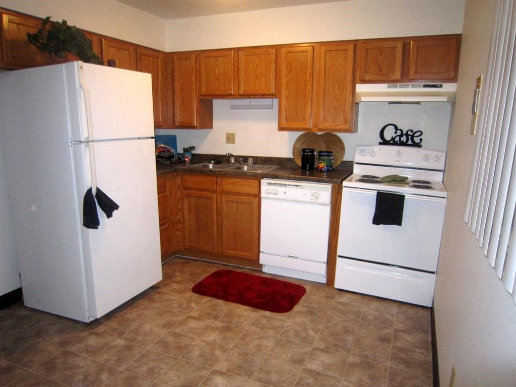 a kitchen with a white refrigerator freezer next to a stove top oven