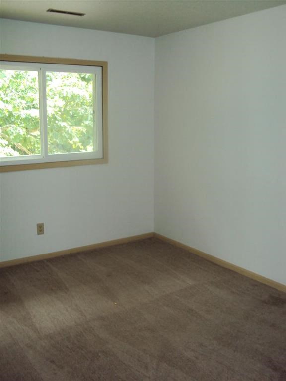 an empty room with a window and a carpet