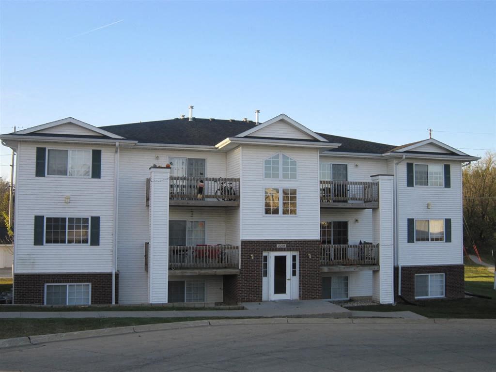 an apartment building with two balconies and a white door