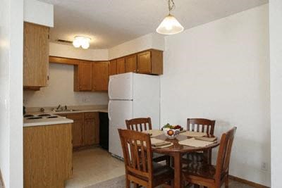 a kitchen with a table and chairs and a refrigerator