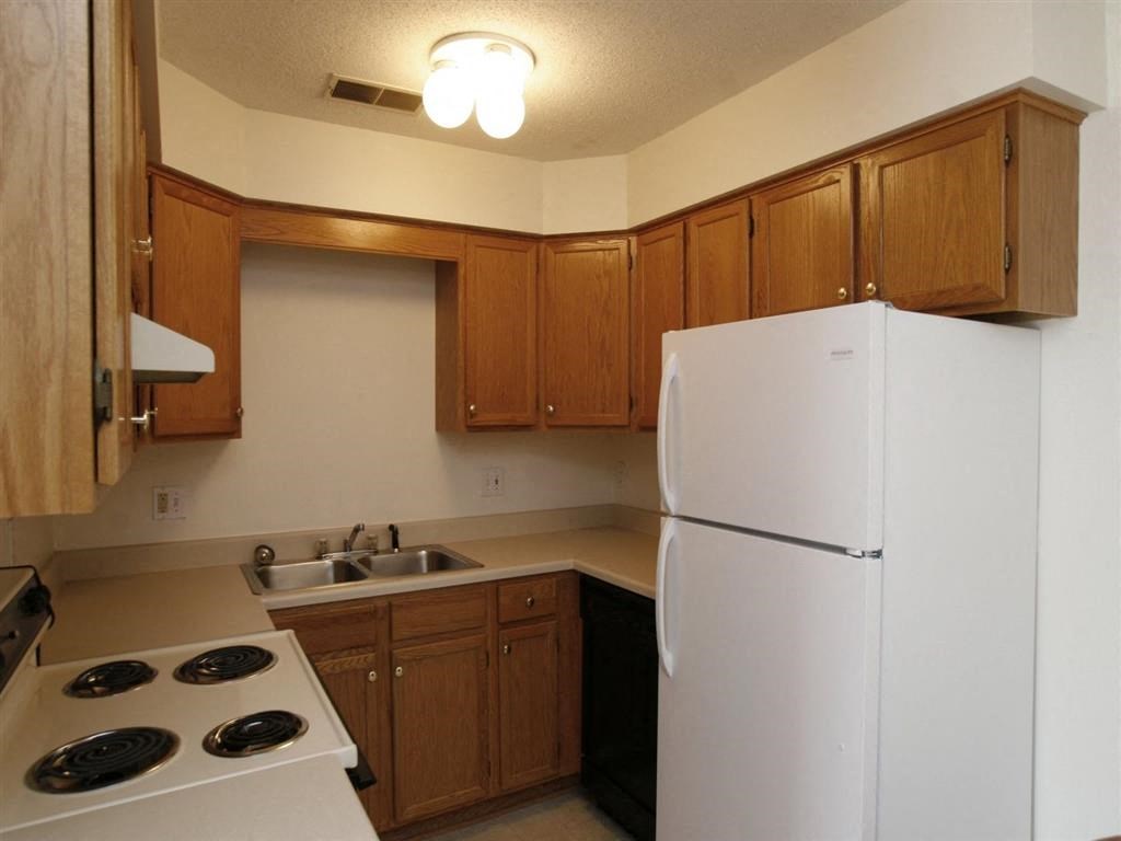 a kitchen with a white refrigerator freezer next to a stove top oven