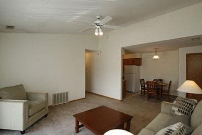 a living room with a couch a table and a ceiling fan