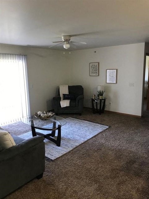 a living room filled with furniture and a ceiling fan