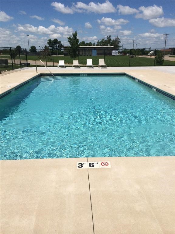 a large swimming pool with a blue sky in the background
