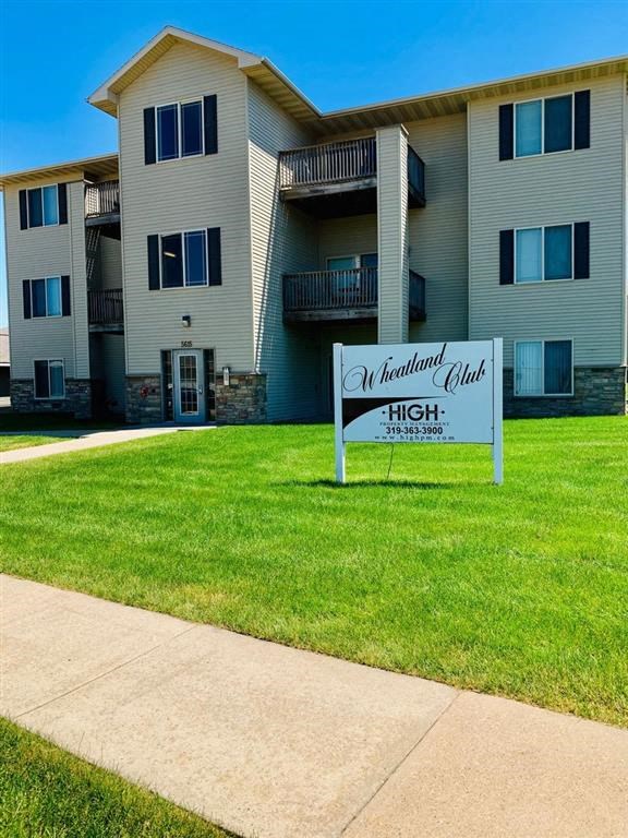 an apartment building with a sign in front of it