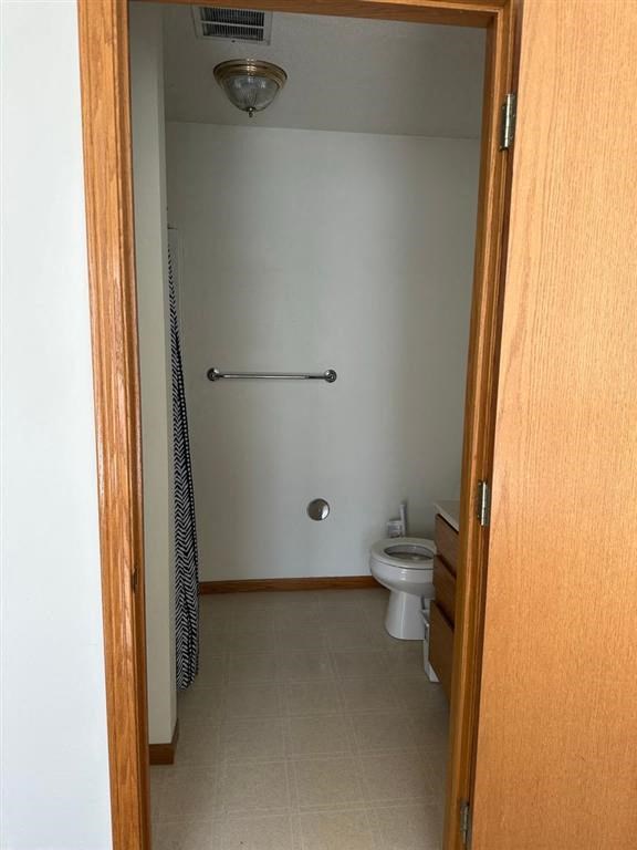 a white toilet sitting in a bathroom next to a shower