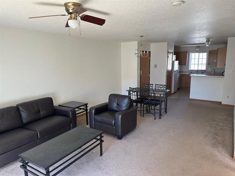 a living room with leather furniture and a dining room table