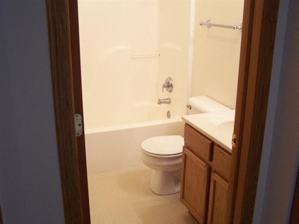a white toilet sitting next to a white bath tub