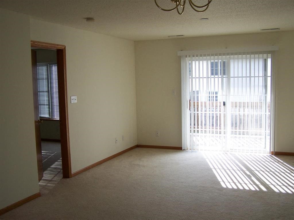 an empty living room with a sliding glass door